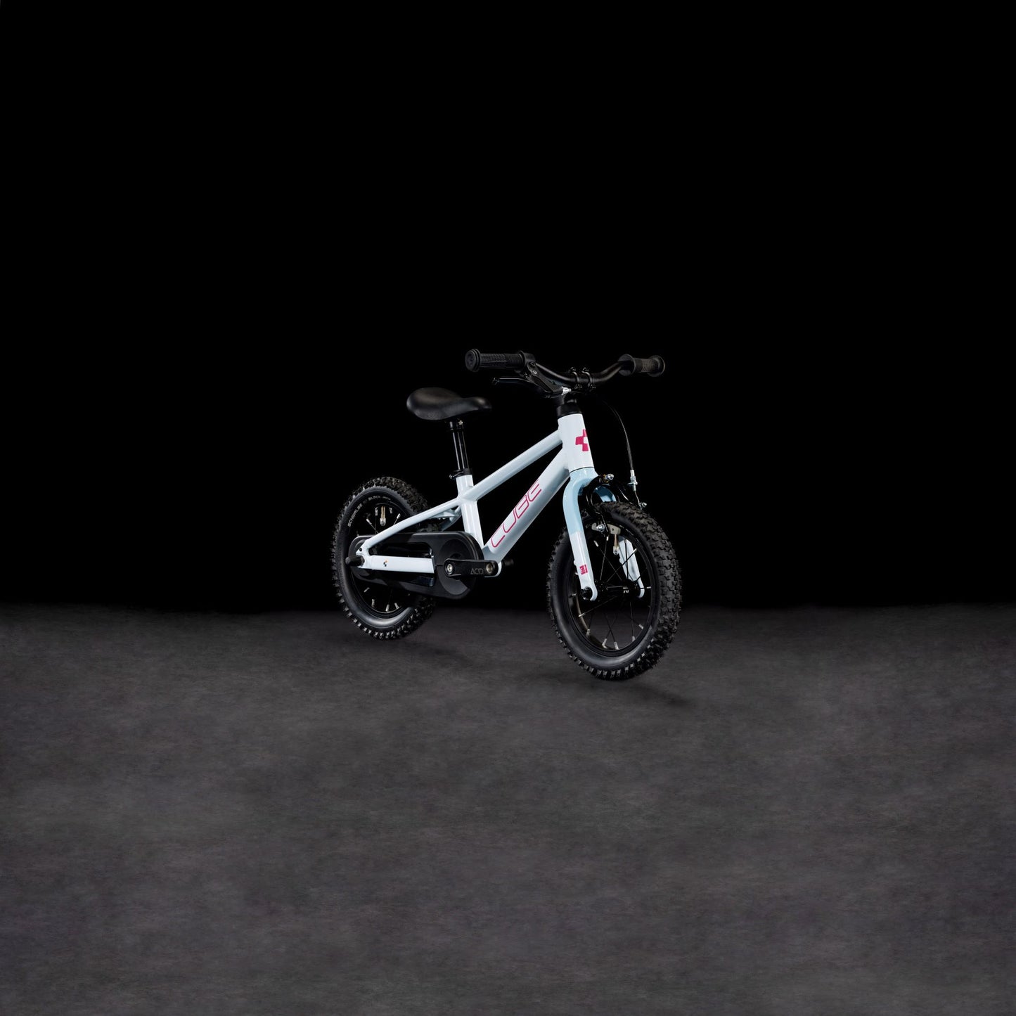 Ein CUBE Numove 120 RT flashwhite'n'pink 2025 Kinderfahrrad mit Stützrädern und einem stabilen Aluminiumrahmen wird vor einem schlichten schwarzen Hintergrund präsentiert.