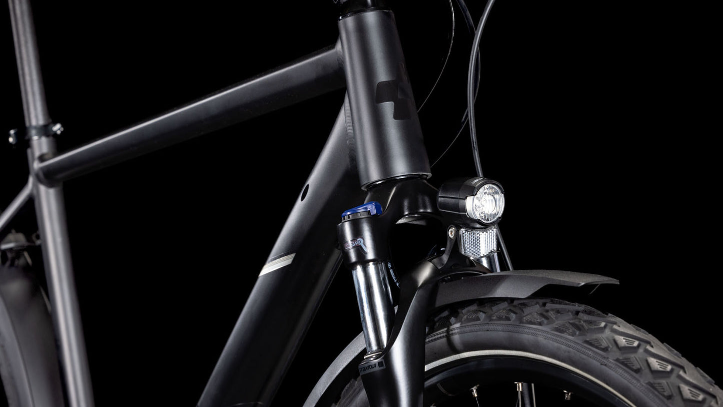 Nahaufnahme der Front des CUBE Nature ONE Allroad black'n'black, die Rahmen, Federgabel, Reifen, Vorderlicht und Schutzblech vor schwarzem Hintergrund hervorhebt. Verfügt über hydraulische Scheibenbremsen für überlegene Bremskraft.