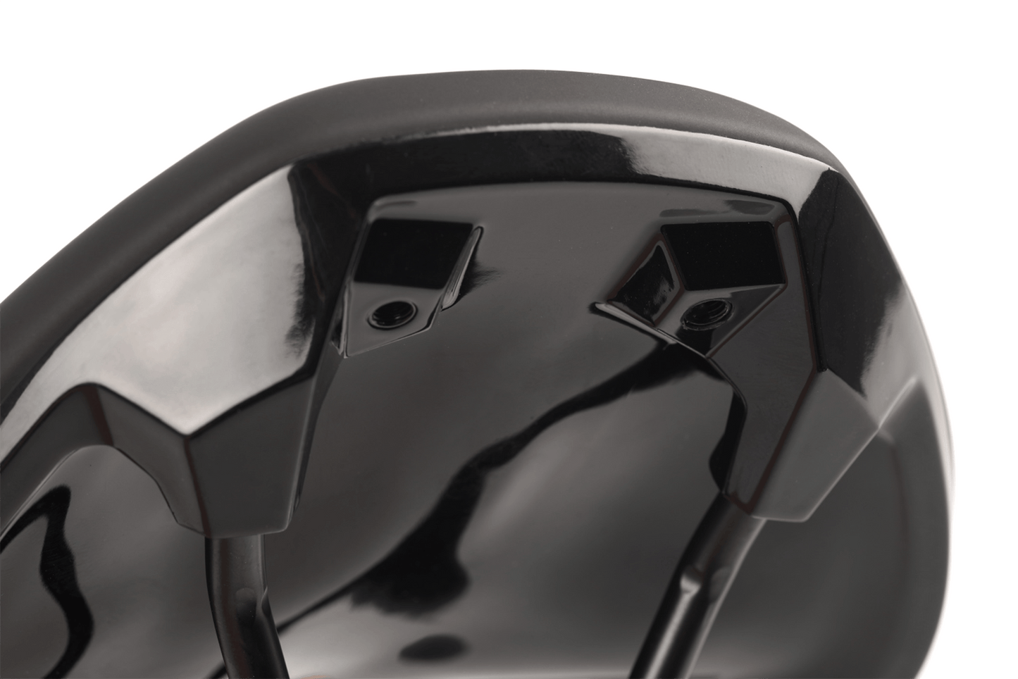 Die Nahaufnahme der Unterseite des Natural Fit Sattel Sequence+ Regular zeigt die schwarz glänzende Oberfläche, die Montagebügel und die Schienen. Die spiegelnde Oberfläche hebt die ergonomische Designline und die Deep-Shell Sattelschale für zusätzlichen Komfort hervor.