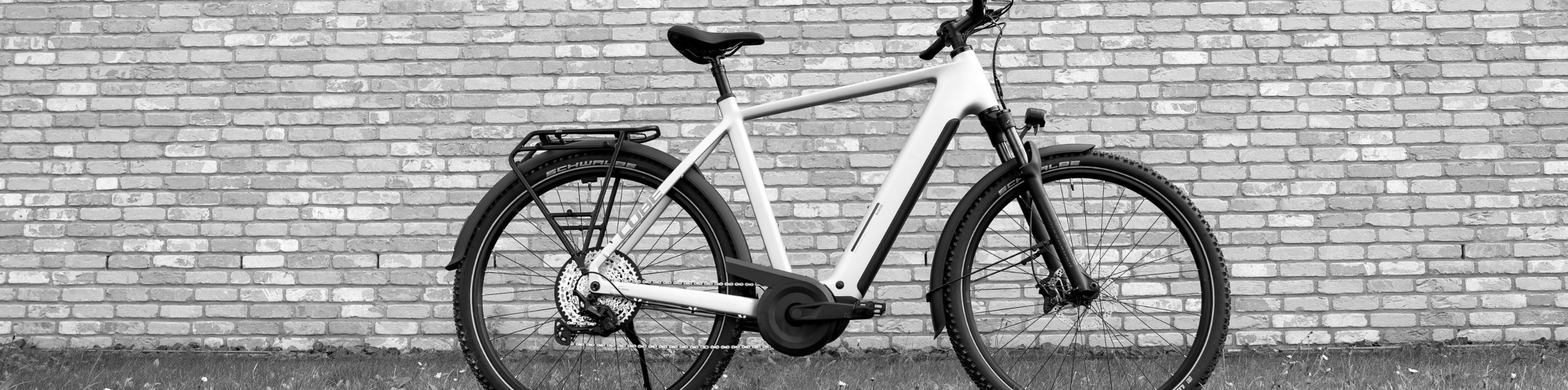 E-Trekking und E-City SALE – CUBE E-Trekkingrad vor Backsteinwand reduziert