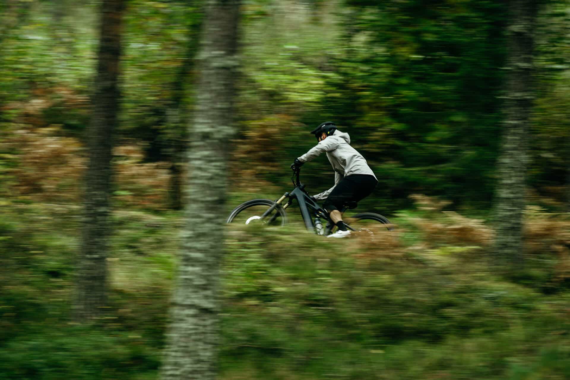 CUBE Neuheiten 2026 – Mountainbiker auf neuem Modell fährt schnell durch grünen Wald