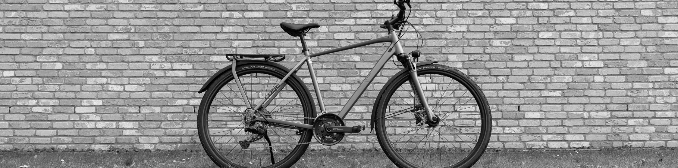 Trekking und City Bike SALE – CUBE Trekkingrad vor Backsteinwand reduziert
