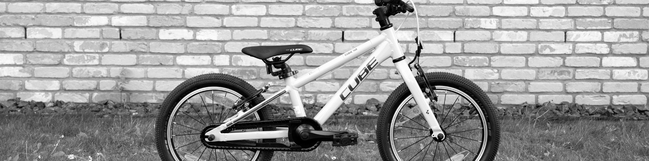 Kids SALE – CUBE Kinderfahrrad vor Backsteinwand reduziert im CUBE Store