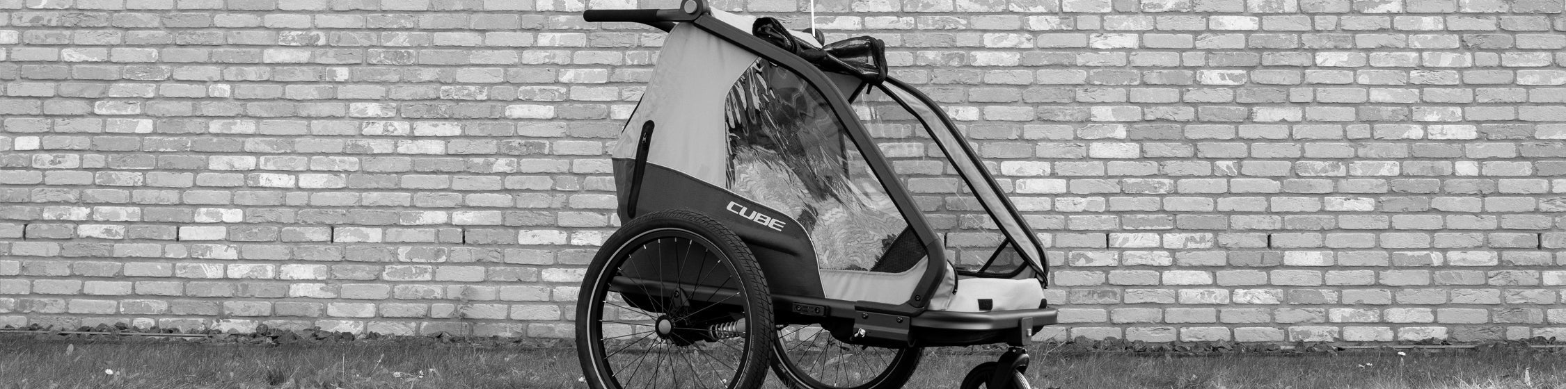 Fahrrad Zubehör SALE – Kinderanhänger vor Backsteinwand zu reduziertem Preis