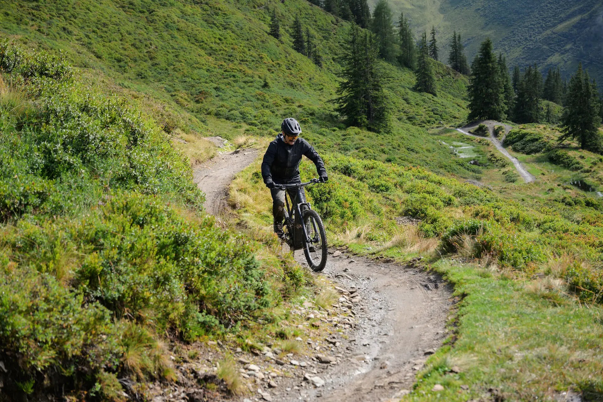 CUBE Stereo Hybrid ONE22 E-MTB Fully – Mountainbiker fährt auf schmalem Trail durch Laub