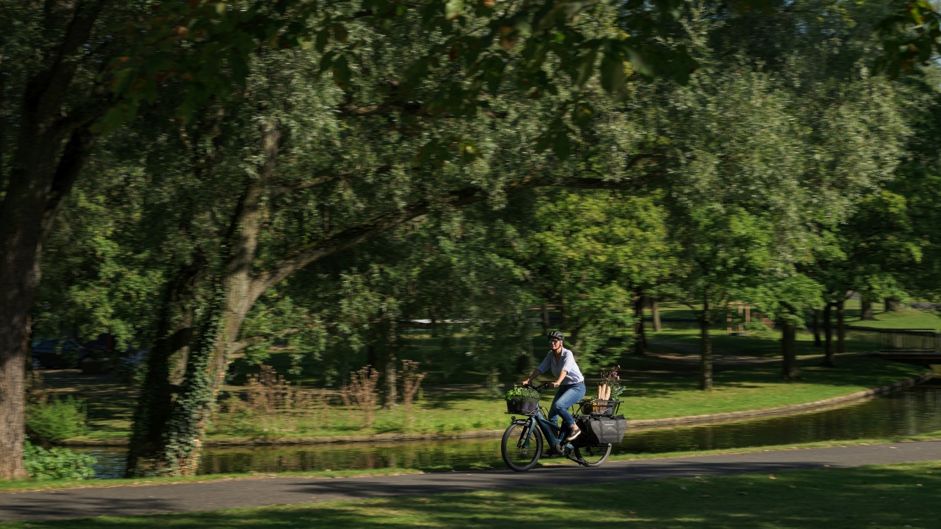 Zubehör für CUBE Longtail Hybrid E-Lastenrad – Mensch auf Cargo Bike im Park
