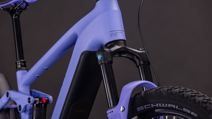 Die Nahaufnahme des CUBE Stereo Hybrid ONE22 Pro 800 lucidlilac'n'lime 2026 zeigt den mattvioletten Rahmen, die Federgabel und die schwarzen Komponenten mit einem Schwalbe-Reifen vor einem dunklen Hintergrund.