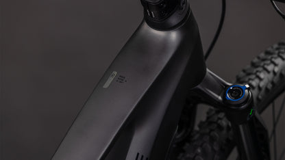 Nahaufnahme des mattschwarzen CUBE Stereo Hybrid ONE22 Race 800 slabgrey'n'chrome 2026 Rahmens, der das Oberrohr, die Vorderradaufhängung, die Shimano 12-fach XT Schaltung und das Reifenprofil vor einem dunklen Hintergrund hervorhebt.
