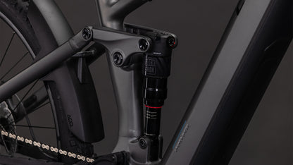 Nahaufnahme des CUBE Stereo Hybrid ONE22 Race 800 slabgrey'n'chrome 2026 von CUBE. Zu sehen sind die Hinterradfederung mit RockShox-Dämpfer, der Bosch CX-Motor, der sauber in den matten Rahmen integriert ist, sowie Kette und Hinterrad.