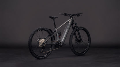 Das CUBE Stereo Hybrid ONE22 Race 800 slabgrey'n'chrome 2026, ein mattgraues E-Fully-Mountainbike mit Bosch CX-Motor und Shimano 12-Gang-XT-Schaltung, ist auf einem dunklen Hintergrund abgebildet, der seine dicken Reifen und den schlanken, vollgefederten Rahmen hervorhebt.