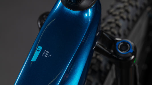 Nahaufnahme eines blauen CUBE Stereo Hybrid ONE22 Race 800 electricblue'n'white 2026 E-MTB-Rahmens mit der Aufschrift RACE SIZE: M H:22°, die einen Teil der vorderen Federgabel, Reifen und Platz für einen 800 Wh Akku zeigt.
