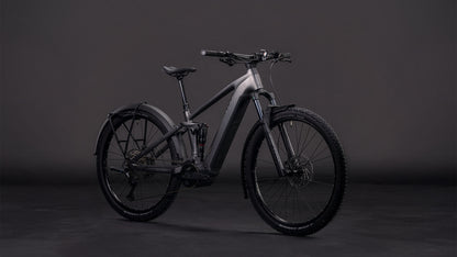 Das CUBE Stereo Hybrid ONE22 Race 800 FE slabgrey'n'chrome 2026, ein modernes E-Mountainbike mit Bosch CX-Motor, Vollfederung und dicker Bereifung, wird vor dunklem Hintergrund in Szene gesetzt.