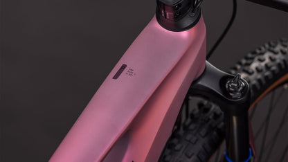 Nahaufnahme des CUBE Stereo Hybrid ONE44 Pro 800 shiftblush'n'raisin 2026 Rahmens, die das Oberrohr, die Federgabel und ein kleines Display zeigt. Ausgestattet mit Bosch CX-Motor; der Hintergrund ist dunkel und unscharf.