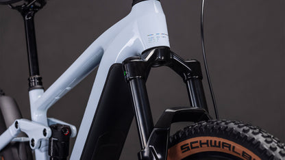 Nahaufnahme der CUBE Stereo Hybrid ONE44 EX 800 iceblue'n'prism 2026 Federgabel und des Schwalbe-Laufrads vor einem dunklen Hintergrund, der die leistungsstarke Bosch CX-Antriebsleistung zeigt.