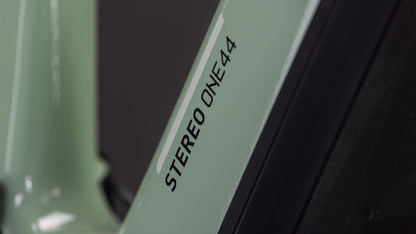 Nahaufnahme eines CUBE Stereo Hybrid ONE44 HPC Race 800 (2026) Rahmens in driedherbs'n'black mit dem Text "STEREO ONE44" in Schwarz auf der hellgrünen Oberfläche.