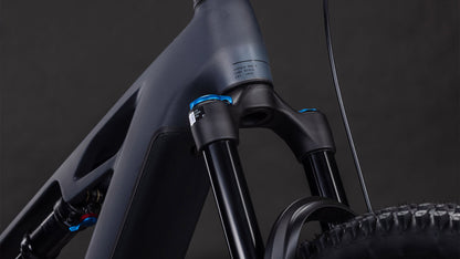 Nahaufnahme des CUBE Stereo Hybrid ONE44 HPC SLX 800 slabgrey'n'orange 2026 mit Federgabel, mattgrauem Rahmen mit orangefarbenen und blauen Akzenten und Vorderradreifen - ein Beweis für modernste E-Bike-Technik.