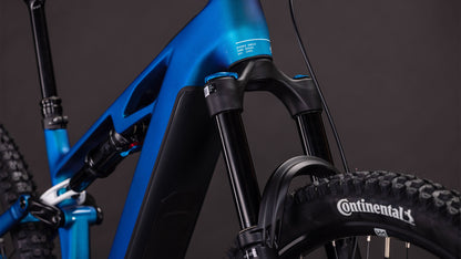 Nahaufnahme des CUBE Stereo Hybrid ONE44 HPC SLX 800 nebula'n'white 2026 mit Federgabel, Reifen mit Continental Branding und Rahmen. Mit Shimano XT Schaltung für reibungslose Schaltvorgänge vor einem dunklen, neutralen Hintergrund.