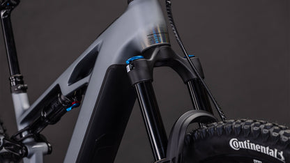 Nahaufnahme der vorderen Federgabel, des Rahmens und des Laufrads des CUBE Stereo Hybrid ONE44 HPC SLX Evo 800 mit dem Continental-Reifenbranding und einem Bosch CX-Motor auf der rechten Seite vor einem dunklen Hintergrund.