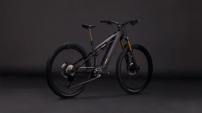 Das CUBE Stereo Hybrid ONE44 HPC AT 800 carbon'n'gold 2026 Elektro-Mountainbike besticht durch sein modernes schwarz-goldenes Design, die dicken Reifen, den Bosch CX-Motor und die auffällige goldene Federgabel, die sich auf dunklem Grund präsentiert.