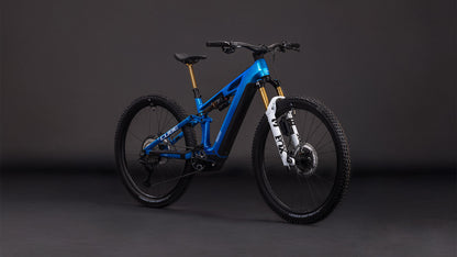Ein blaues CUBE Stereo Hybrid ONE44 HPC AT 800 actionteam 2026 vollgefedertes Mountainbike mit schwarzen Laufrädern, weißer Vorderradgabel, großer Bereifung, Shimano XT Scheibenbremsen und einem leistungsstarken Bosch CX Motor steht vor einem dunklen Hintergrund.