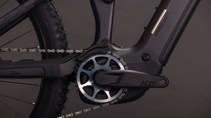 Nahaufnahme der Kurbelgarnitur, der Kette, des Pedals, des vorderen Ritzels und des Bosch CX Motors am CUBE Stereo Hybrid ONE77 HPC SLX 800 blackline 2026. Der Rahmen ist mit Stereo ONE77 170 mm Federweg gekennzeichnet. Dunkler, minimaler Hintergrund.