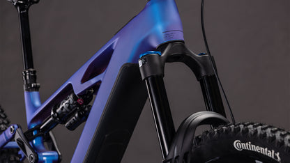 Nahaufnahme des CUBE Stereo Hybrid ONE77 HPC SLX 800 blueiris'n'black 2026 E-MTB, mit Bosch CX-Motor, Federgabel vorne, mattblauem Rahmen, Stoßdämpfer hinten und Continental-Reifen vor dunklem Hintergrund.