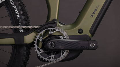 Nahaufnahme des Cube Stereo Hybrid ONE77 HPC TM 800 reedgreen'n'matrix 2026 von CUBE. Hervorzuheben sind die Kurbelgarnitur, das Kettenblatt, die Kette, der Pedalarm, der KRYPTOTAL-Hinterreifen, der schilfgrüne Rahmen mit schwarzen Akzenten und der leistungsstarke Bosch CX-Motor.