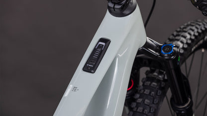 Nahaufnahme des CUBE AMS Hybrid ONE44 C:62 Race 400X reedbeige'n'black 2026 Rahmens von CUBE, die das Bosch-Bedienfeld und die Batterieanzeige auf dem Oberrohr mit einem Bosch SX Motor zeigt. Die vordere Federgabel und der Reifen sind im Hintergrund zu sehen.