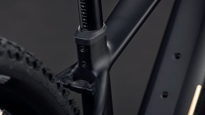 Die Nahaufnahme des CUBE Reaction Hybrid Pro 800 blackline 2026 zeigt den mattschwarzen Rahmen, die Sattelstütze und den hinteren Noppenreifen. Zur Ausstattung gehören ein 800-Wh-Akku und ein leistungsstarker Bosch CX-Antrieb, alles vor einem dunklen Hintergrund.