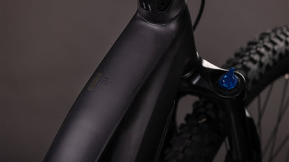 Nahaufnahme des mattschwarzen CUBE Reaction Hybrid Pro 800 blackline Trapeze 2026 Rahmens mit Oberrohr, Federgabel mit blauem Knauf und integriertem Display. Ausgestattet mit Bosch CX Antrieb und 800 Wh Akku; neutraler unscharfer Hintergrund.