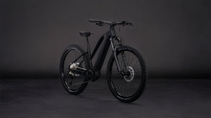 Das CUBE Reaction Hybrid Pro 800 blackline Trapeze 2026 E-Mountainbike präsentiert sich vor dunklem Hintergrund mit dicken Reifen, einem stabilen Rahmen, einer fortschrittlichen Schaltung und einem leistungsstarken Bosch CX-Antrieb mit 800-Wh-Akku für lange Fahrten.