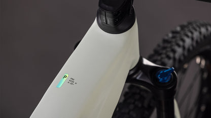 Nahaufnahme des CUBE Reaction Hybrid Pro 800 desertstone'n'driedherbs 2026 Rahmens mit einem kleinen beleuchteten Digitaldisplay, einem Teil des Lenkers, der Federgabel mit Bosch CX-Antrieb und einem Noppenreifen im Hintergrund.