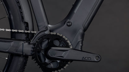 Nahaufnahme einer CUBE Reaction Hybrid Pro 800 FE blackline 2026 E-Bike Kurbelgarnitur und Kettenblatt, mit ACID-gekennzeichnetem Kurbelarm, Rahmen, Kette und Hinterradreifen sichtbar. Mit Bosch CX-Motor für starke Leistung vor dunklem Hintergrund.