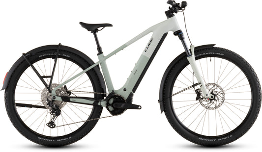 Das CUBE Reaction Hybrid Pro 800 FE desertstone'n'driedherbs 2026 ist ein modernes E-Bike mit dicken schwarzen Reifen, Vorderradaufhängung, Scheibenbremsen, Shimano XT-Schaltung, Schutzblechen und einem Bosch CX-Motor, hier im Profil auf weißem Hintergrund.