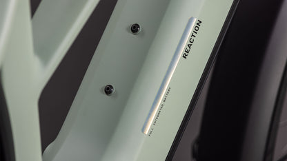 Nahaufnahme eines hellgrünen CUBE Reaction Hybrid Pro 800 FE desertstone'n'driedherbs Trapeze 2026-Rahmens mit zwei Schraubenbefestigungen, dem senkrechten Aufdruck REACTION und dem Aufkleber "FULL INTEGRATED BATTERY" neben dem schwarzen Reifen.