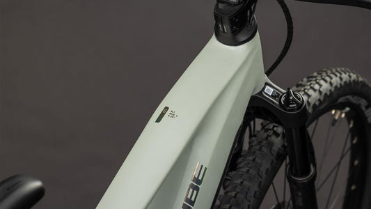CUBE MTB-Rahmen 108700 – Detailaufnahme Steuerrohr und Vorderrad, beige-weiß auf dunklem Hintergrund