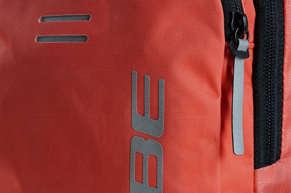 Nahaufnahme des CUBE Rucksacks PURE 6 ROOKIE red'n'black von CUBE mit schwarzem Reißverschluss und grauen reflektierenden Details, entdeckt im CUBE Store in Hildesheim, Niedersachsen; teilweise "BE"-Schriftzug auf dem Material sichtbar.