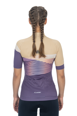 Von hinten ist eine Frau mit zwei Zöpfen zu sehen, die das Cube CUBE TEAMLINE WS Trikot kurzarm violet'n'sand aus funktionellem Material - ideal für Radsportlerinnen - trägt und dazu eine dunkle Radhose trägt.