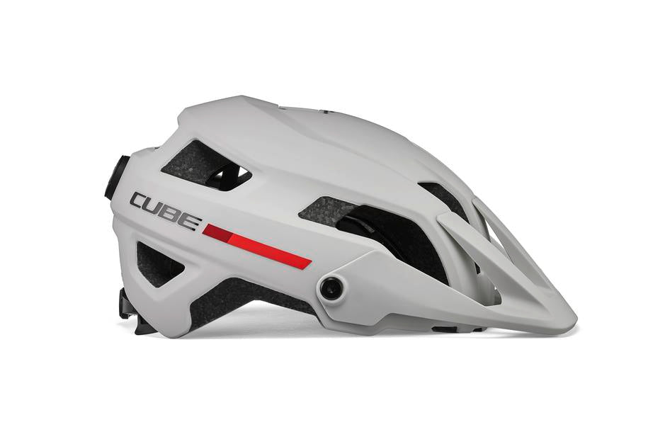 Der CUBE Helm FRISK / MTB Trail Helm von Cube ist ein weißer Helm mit rotem Streifen, seitlichen Belüftungsöffnungen und einem verstellbaren Visier, der mit dem CUBE Natural Fit System ausgestattet ist. Abgebildet in Profilansicht vor einfarbigem Hintergrund.