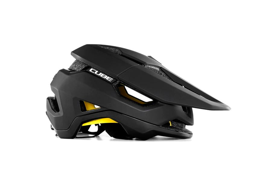 Der CUBE Helm TROOPER von Cube ist ein schwarzer MTB-Enduro-Helm mit Visier, eckigen Belüftungsöffnungen, MIPS-Technologie und gelber Innenpolsterung, der im Seitenprofil auf weißem Hintergrund abgebildet ist.
