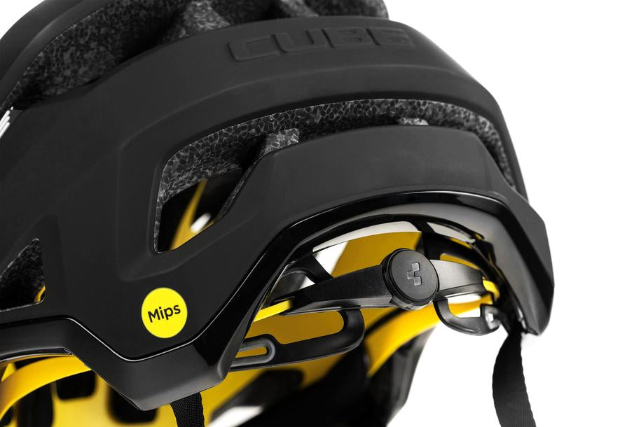 Nahaufnahme des Cube CUBE Helm TROOPER MTB Enduro Helm in schwarz mit gelber Innenausstattung, mit MIPS-Technologie, einem verstellbaren Passformsystem und sichtbarer, strukturierter Schaumstoffpolsterung.