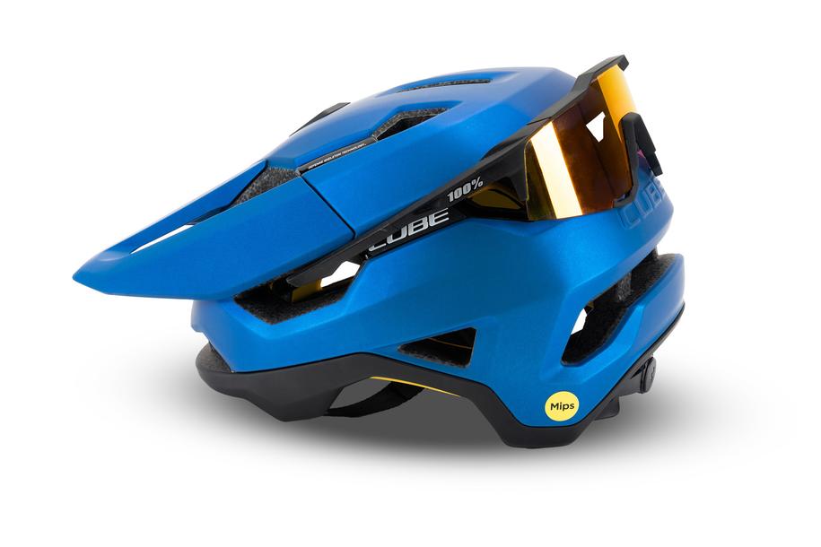 Der Cube CUBE Helm TROOPER ist ein blauer Enduro-Helm mit Visier, Belüftungskanälen, reflektierenden orangefarbenen Sonnenbrillen auf der Vorderseite und einem gelben MIPS Technologie-Sicherheitslogo an der Seite.