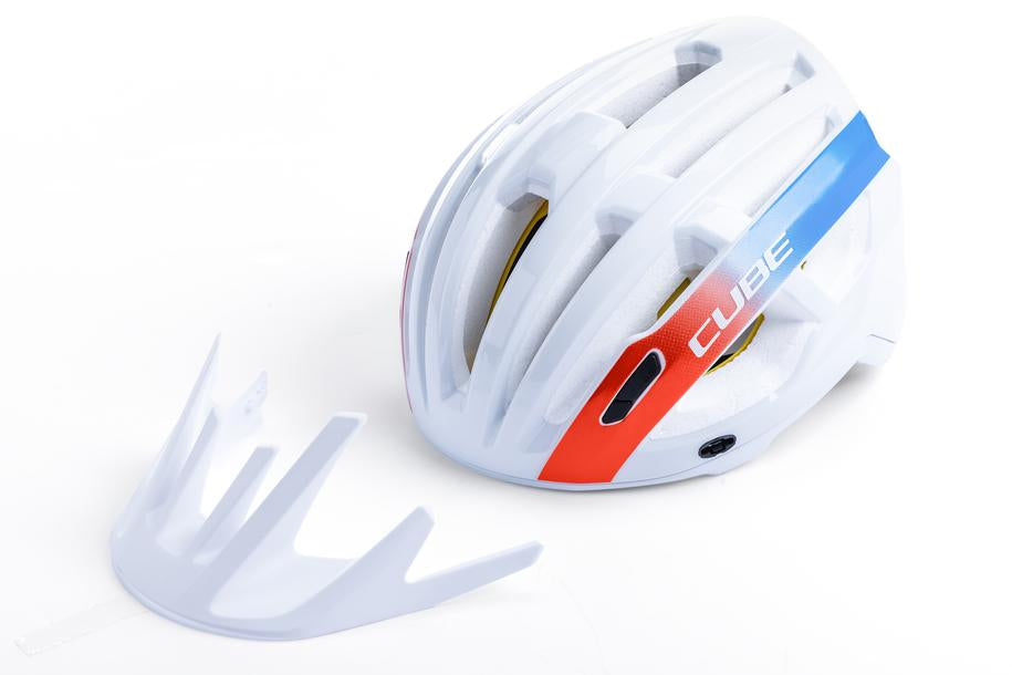Der CUBE Helm OFFPATH Teamline weißer MTB-Rennhelm von Cube hat ein weißes Design mit roten und blauen Streifen, einen auffälligen CUBE-Schriftzug, eine Double-In-Mould-Konstruktion und ist mit einem abnehmbaren weißen Visier auf weißem Hintergrund abgebildet.