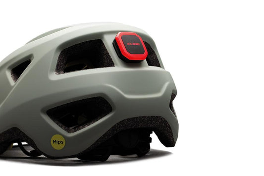 Eine Nahaufnahme des Cube CUBE Helm Rücklicht CMPT, ein grauer Fahrradhelm mit rotem Rücklicht und gelbem Mips-Sicherheitsaufkleber, fotografiert vor weißem Hintergrund, ist bei Radfahrern in Niedersachsen beliebt.