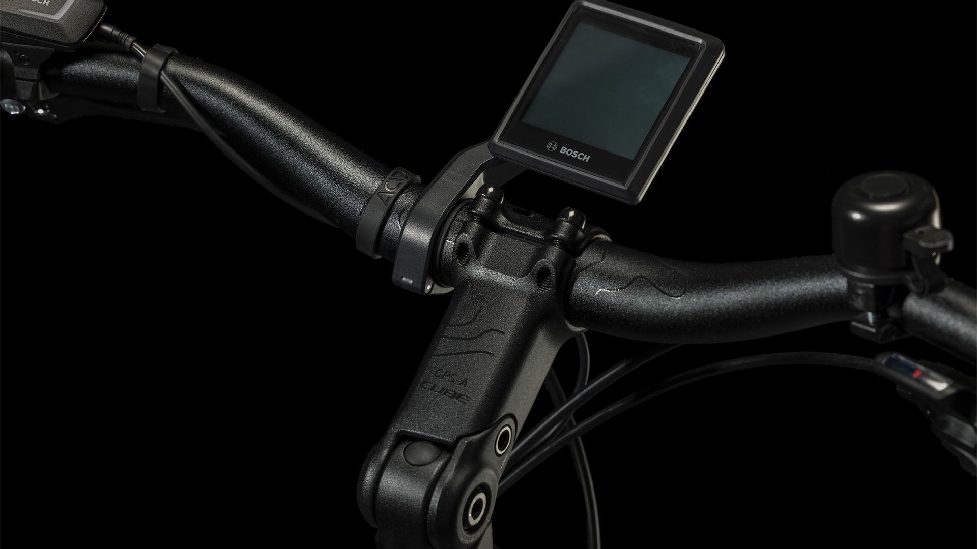 Nahaufnahme des CUBE Touring Hybrid Pro 625 black'n'metal Trapeze 2024 Lenkers mit Bosch Display, Shimano 11-fach Schaltung, Bremshebeln und Klingel vor schwarzem Hintergrund.