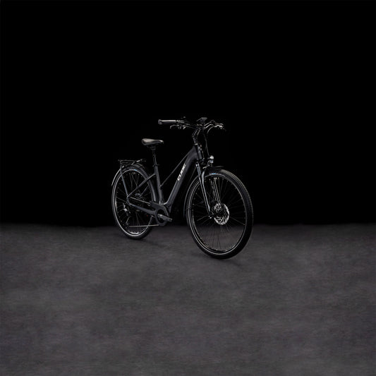 Das CUBE Touring Hybrid Pro 625 black'n'metal Trapeze 2024 Elektrofahrrad mit Vorderradaufhängung ist vor einem dunklen, nahtlosen Hintergrund abgebildet, der die elegante, matte Oberfläche und den integrierten Bosch Performance Motor betont.
