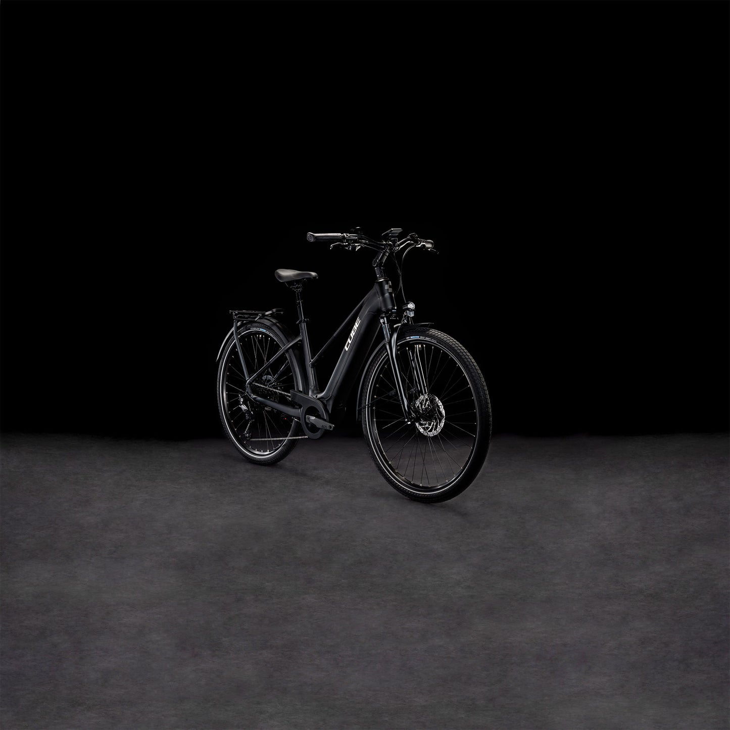 Das CUBE Touring Hybrid Pro 625 black'n'metal Trapeze 2024 Elektrofahrrad mit Vorderradaufhängung ist vor einem dunklen, nahtlosen Hintergrund abgebildet, der die elegante, matte Oberfläche und den integrierten Bosch Performance Motor betont.