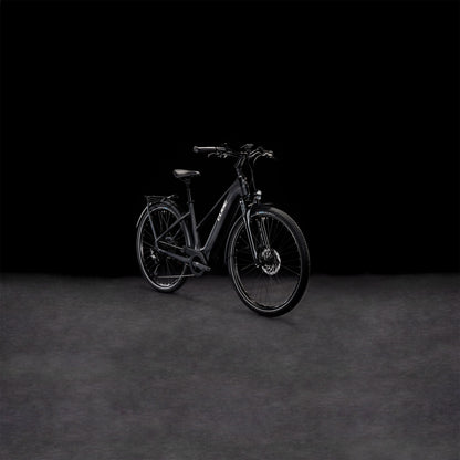 Das CUBE Touring Hybrid Pro 625 black'n'metal Trapeze 2024 Elektrofahrrad mit Vorderradaufhängung ist vor einem dunklen, nahtlosen Hintergrund abgebildet, der die elegante, matte Oberfläche und den integrierten Bosch Performance Motor betont.