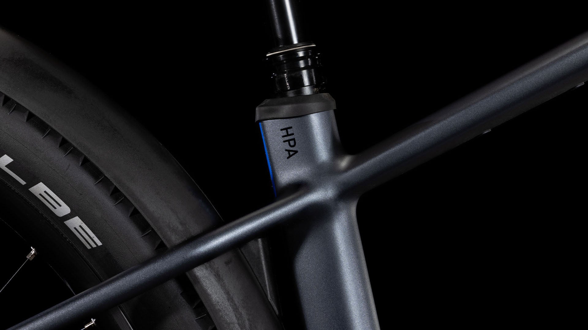 Nahaufnahme des CUBE Reaction Hybrid Pro 800 Allroad metallic grey'n'black 2025 Rahmens mit HPA-Details, Sitzrohr, Oberrohr, Hinterrad mit Schwalbe-Reifen und leistungsstarken Shimano XT Komponenten vor schwarzem Hintergrund.