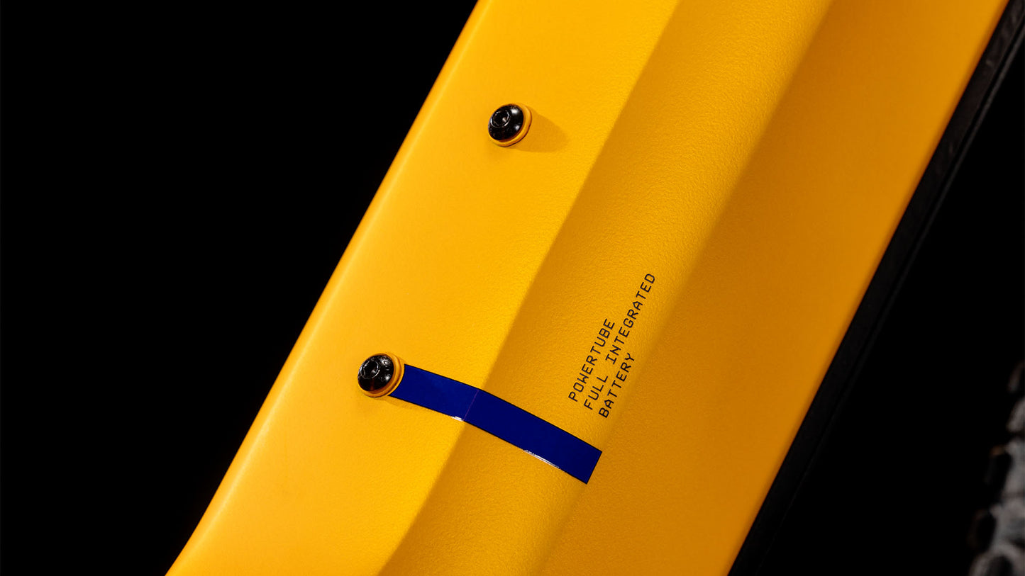 Nahaufnahme eines CUBE Reaction Hybrid SLX 800 spectraorange´n´violet Easy Entry 2025 Rahmens mit zwei Befestigungsschrauben, blauem Akzent und dem Schriftzug „PowerTube Fully Integrated Battery“. Der Fahrradreifen ist rechts teilweise sichtbar.